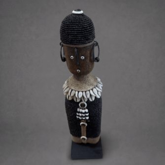 Namji Puppe mit schwarzem Kleid & Kaurimuschel-Kragen (Kamerun) – Mittel