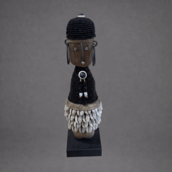 Baby Namji Puppe mit schwarzem Oberteil und Kaurimuschel-Rock (Kamerun) – XS